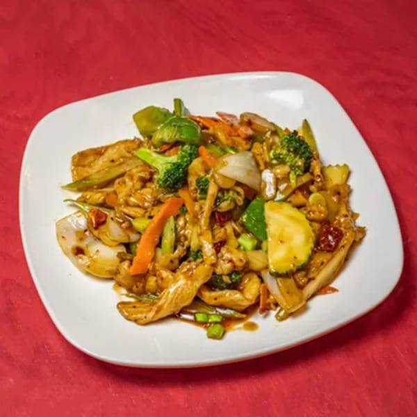 Asian stir-fry with chicken, broccoli, carrots, onions, and zucchini on a white plate.