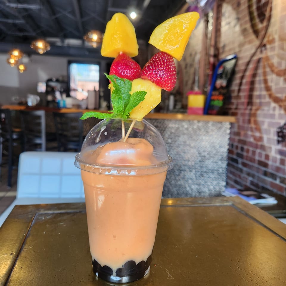 Heavenly Asian Cuisine & Lounge's mango smoothie with boba, topped with fresh mango, strawberries, pineapple, and mint.