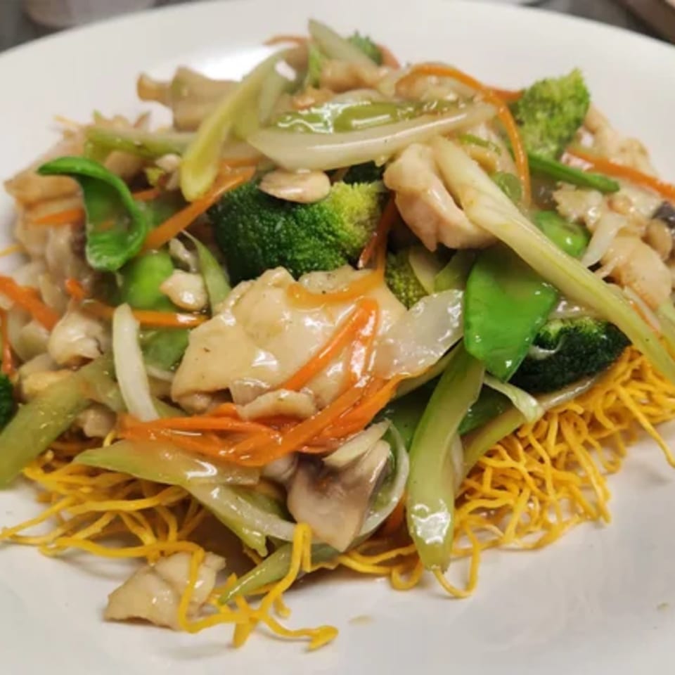 Heavenly Asian Cuisine's crispy noodles topped with chicken, broccoli, carrots, and snow peas.